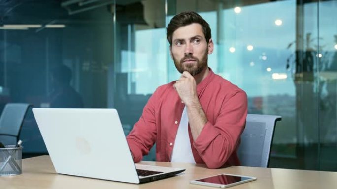 专注成熟的商人企业家在笔记本电脑上工作，商人思考解决创业问题，项目穿着红色衬衫的忙碌英俊男性