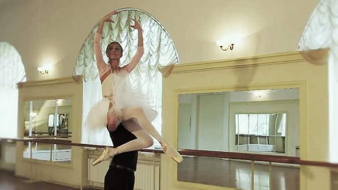 男芭蕾舞演员将芭蕾舞演员的手臂举在头顶上方