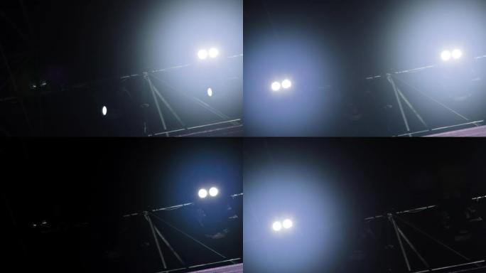 音乐表演过程中，建筑物上舞台灯光的闪烁和旋转光束。