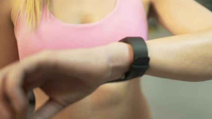 运动女性在健身房开始锻炼前安装智能手表，积极生活