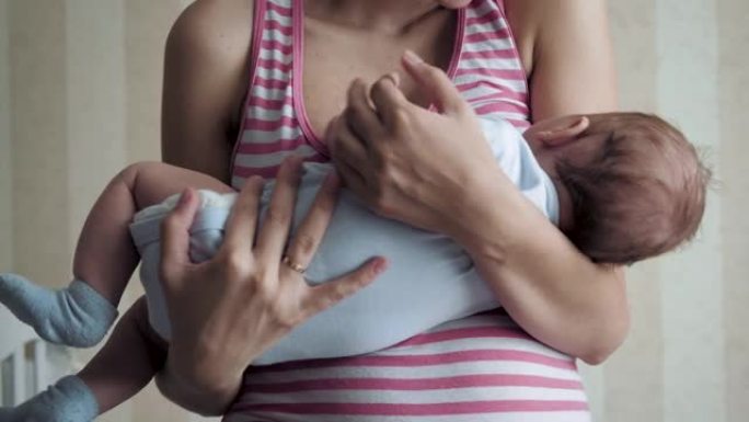 妈妈将婴儿抱在怀里以使婴儿平静并使新生儿入睡
