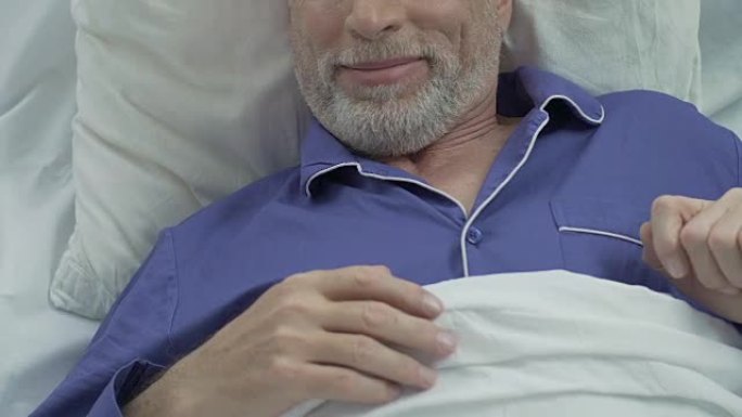 老人躺在床上，醒来后伸展，脸上微笑，睡得很香