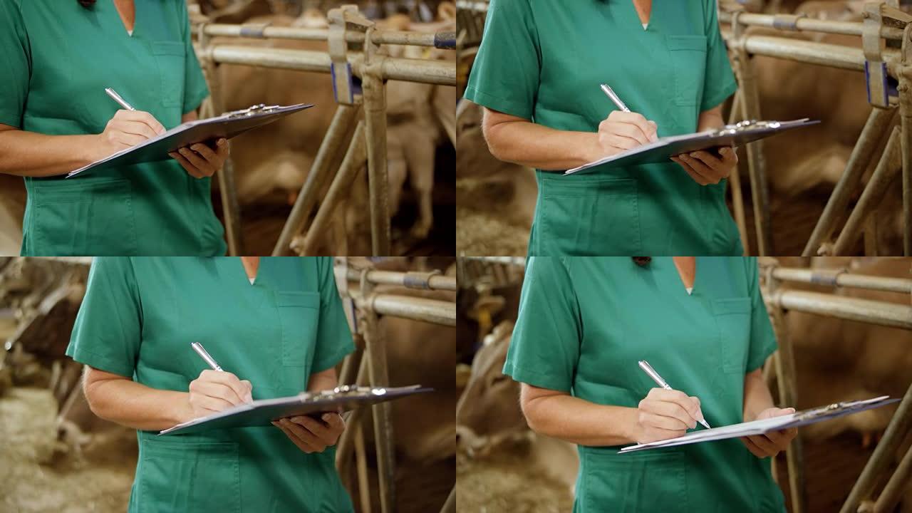 站在谷仓里的女兽医在剪贴板上写字的手