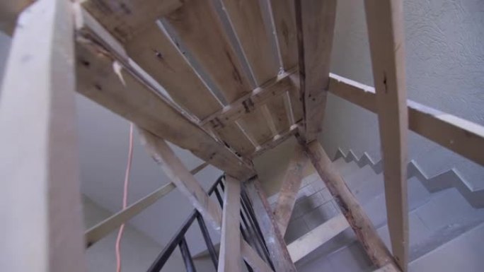 建筑中空楼梯上的建筑工人用木制脚手架