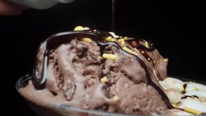 巧克力冰淇淋和糖丸旋转，我将它们倒入巧克力，特写