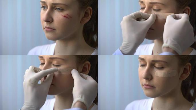 急救措施，医生在受伤的女性患者脸上贴补丁，特写