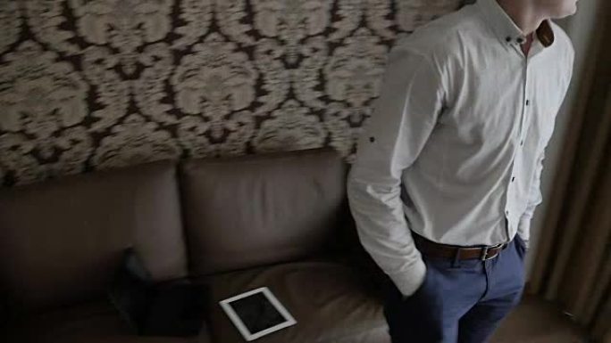 男人把平板电脑从沙发上站起来。