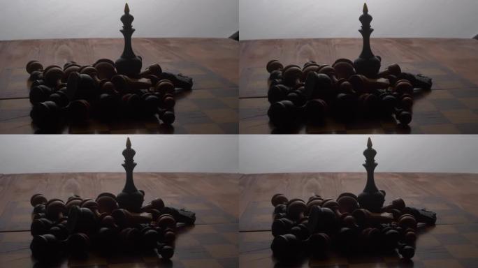 国际象棋棋子黑皇后站在棋盘上，周围是其他躺着的棋子。棋盘游戏。摄像机沿着物体移动