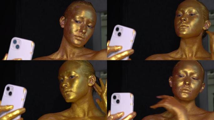 模特的脸上涂有金漆，看着手机。