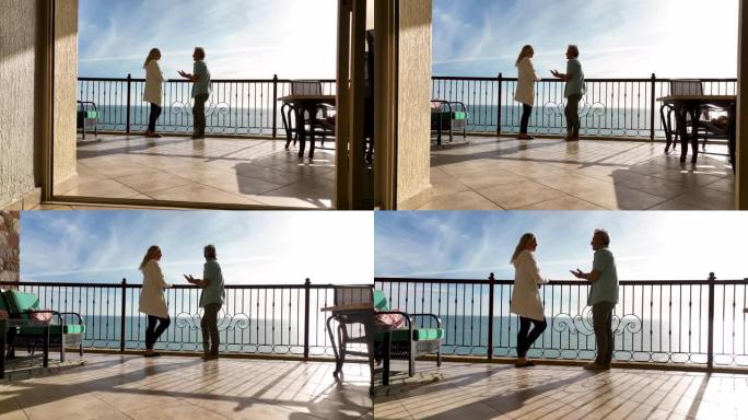 从公寓内部到成熟夫妇在阳台上放松欣赏海景的鸟瞰图
