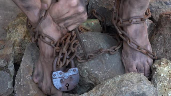 用铁链绑住奴隶的手脚。