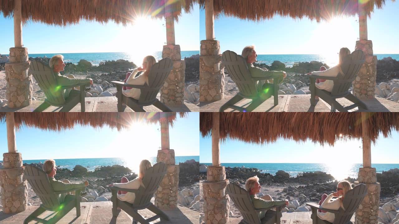 成熟的夫妇在帕拉帕下的沙滩椅上放松，交谈