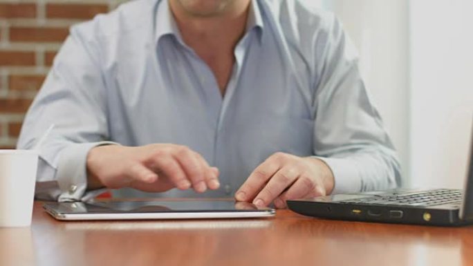 男人在平板电脑上浏览互联网页面，在线阅读新闻提要