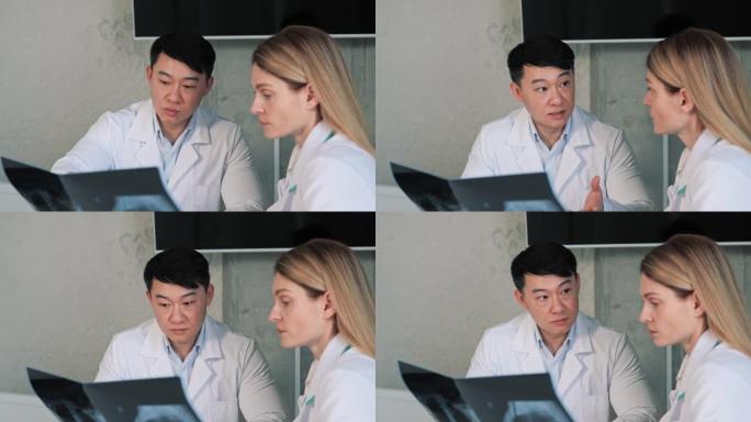 两位国际医生谈工作，分析病人x光片，谈结果分析保健诊所，亚洲主任外科医生和放射科医生讨论病人肺部图像