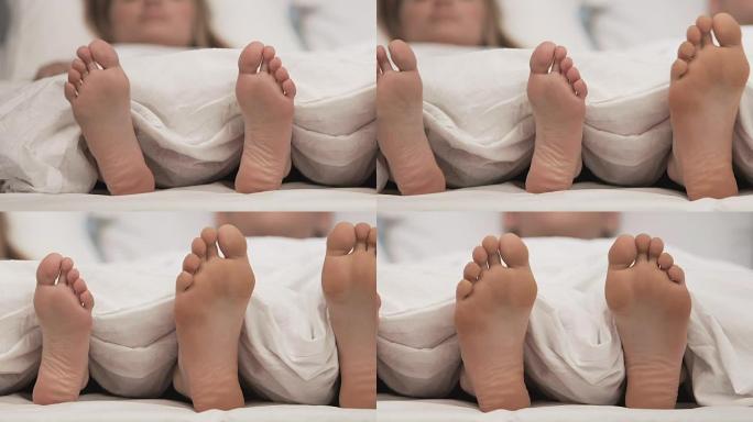 舒适床上的情侣脚，蜜月睡觉时间，浪漫休息