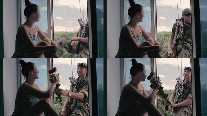 英俊的障碍者在窗台上向美丽的女孩赠送一束玫瑰