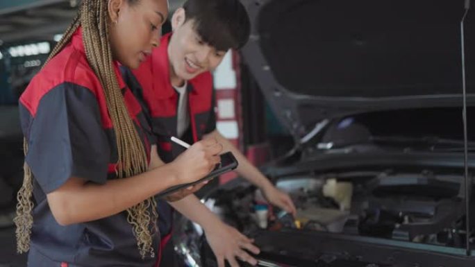 汽车服务、维修、保养理念。机械师在服务站检查汽车。工业到发动机维修的服务维护。非裔美国妇女和亚洲工程