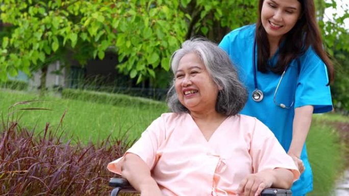 亚洲细心的照顾者或护士在轮椅上照顾病人。从照顾者，储蓄和高级健康保险，一个幸福的家庭，照顾幸福的退休