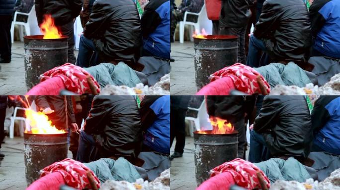 贫穷的人在火附近取暖垃圾桶，冬天在户外