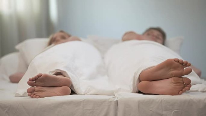 已婚夫妇背靠背躺着生气地看着对方，在床上吵架