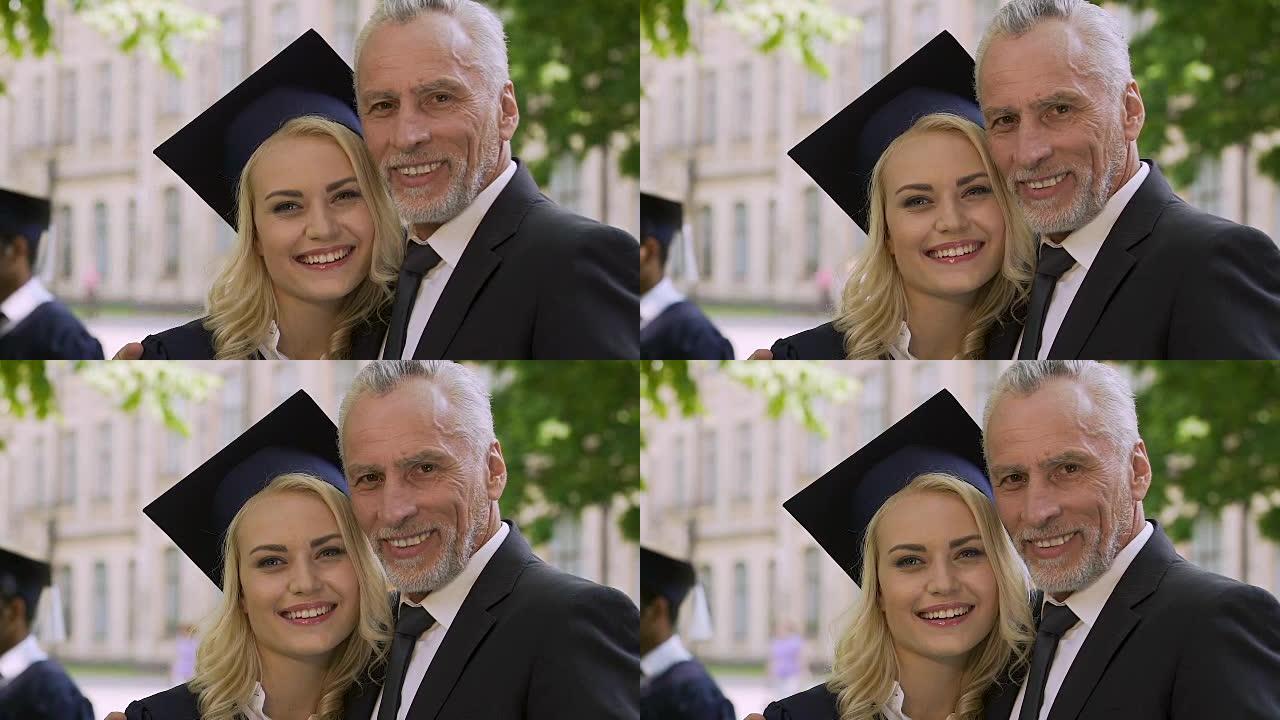 快乐的父亲为他聪明的女儿以优异的成绩从大学毕业而自豪