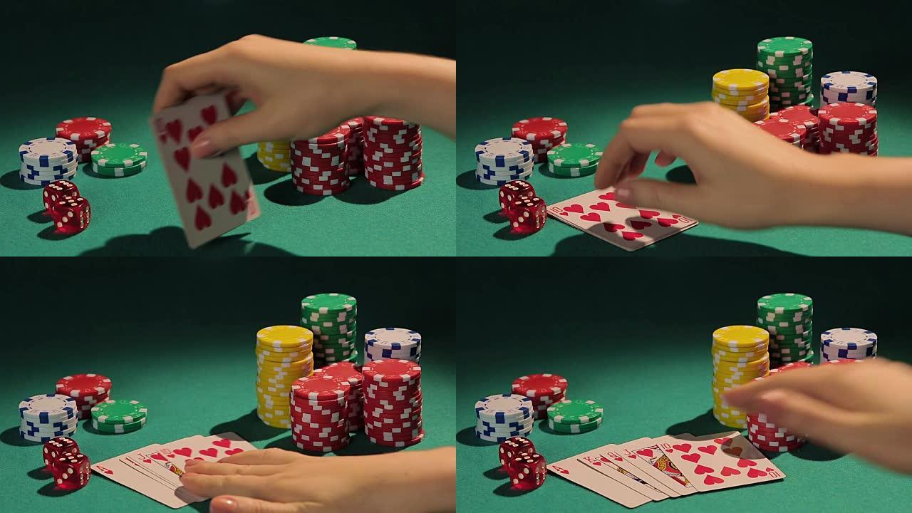 快乐的女性扑克玩家显示最好的扑克组合，皇家同花顺