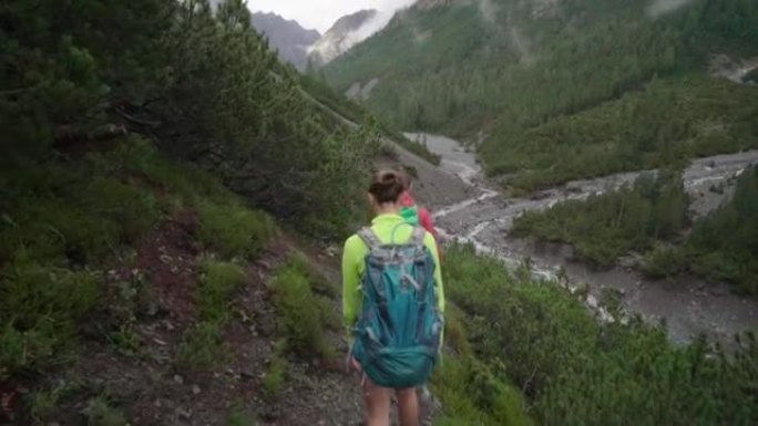 徒步旅行者的队伍沿着树木繁茂的小径驶向山涧