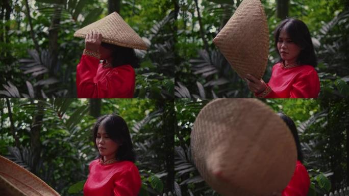 一位穿着红色衣服的妇女在竹桥中间向伴侣扔了一顶竹帽，表情愤怒
