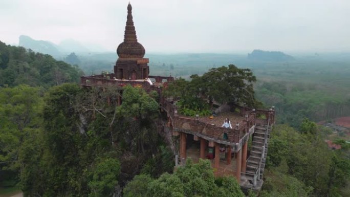 站在泰国丛林山上的佛教寺庙中的女人的鸟瞰图