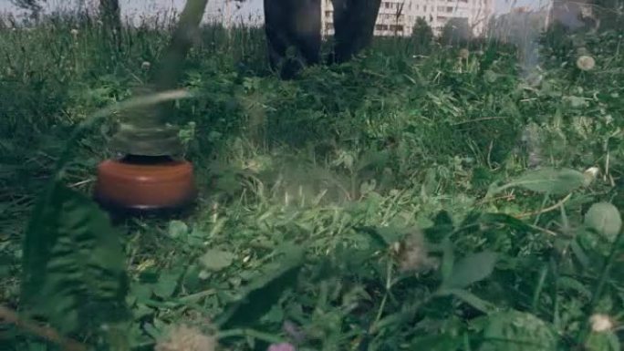 割草机割高绿草，一片片草飞来飞去。慢动作，慢动作