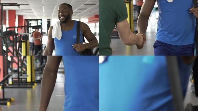 肌肉发达的非洲裔美国男子在健身房里面带微笑，会见朋友