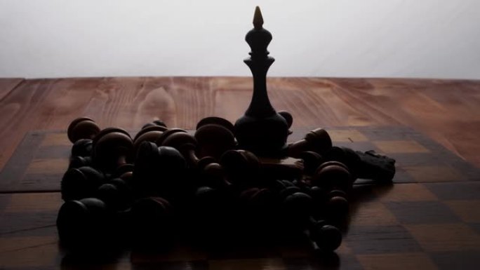黑皇后站在棋盘上，被其余的棋子包围着。棋盘游戏。摄像机沿着物体移动
