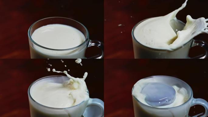 慢动作巧克力曲奇饼干落入透明的杯子中，牛奶在黑暗的背景下。牛奶滴向侧面飞溅