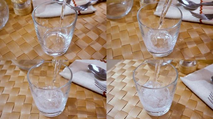 矿泉水倒入玻璃杯中，早晨早餐，慢动作与旋转跟踪拍摄。