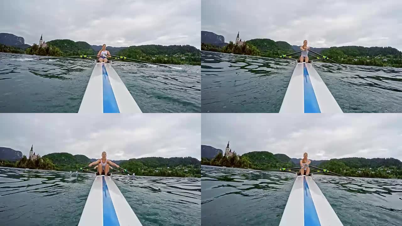 一个女双桨手滑过一个湖的船尾视图