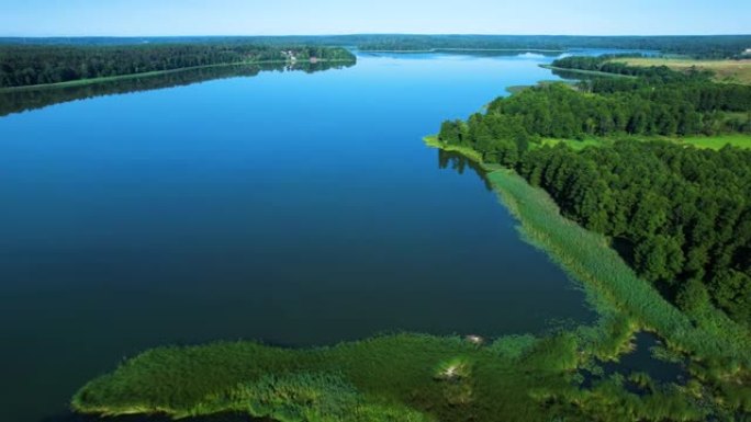 波兰平静湖与岛屿的雄伟鸟瞰图。天堂湖畔的村舍。和平反映在水上。壮观美丽的湖泊鸟瞰图。史诗般的惊人的自