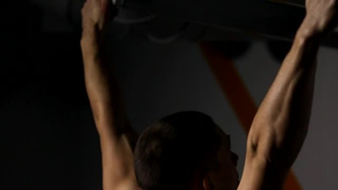 轧辊男子在健身房表演引体向上特写。你可以看到所有的肌肉