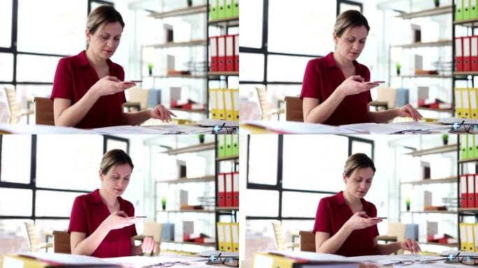 女商人在办公室用手机拍摄文件4k电影慢动作