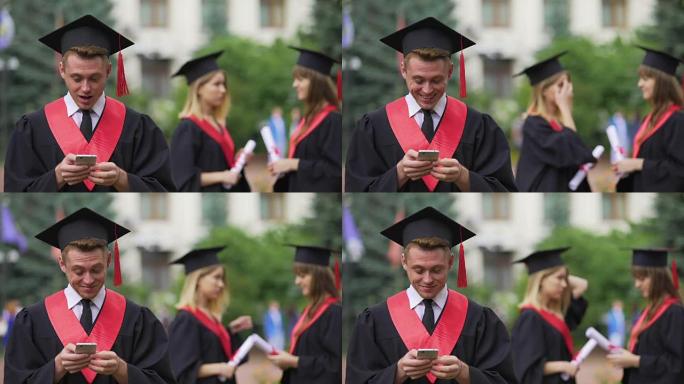 学院附近的智能手机上的毕业生浏览，背景上的朋友聊天