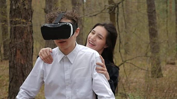 年轻女孩从后面用虚拟现实眼镜吓唬她的男朋友