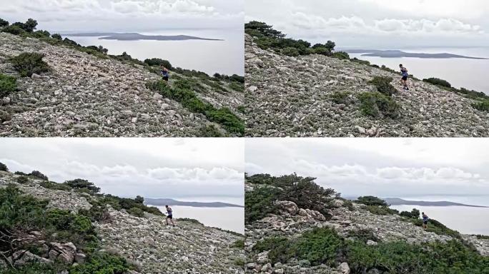 空中的男性跑步者，在海面上的一座岩石山上跑步，远处有岛屿