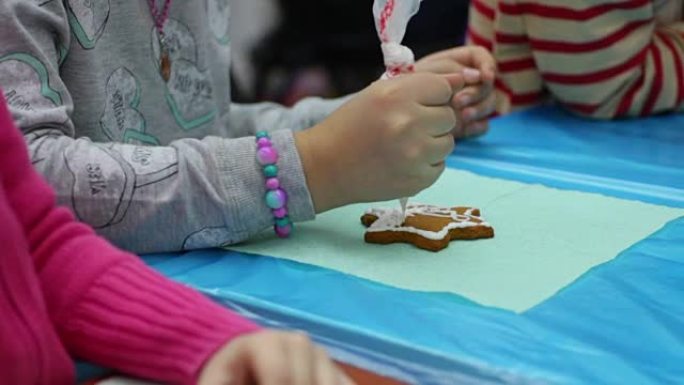 小女孩用彩釉装饰姜饼，烘焙工艺，手工制作