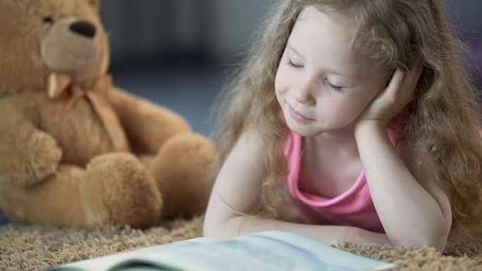 可爱的小女孩沉浸在童话中，饶有兴趣地阅读最喜欢的书