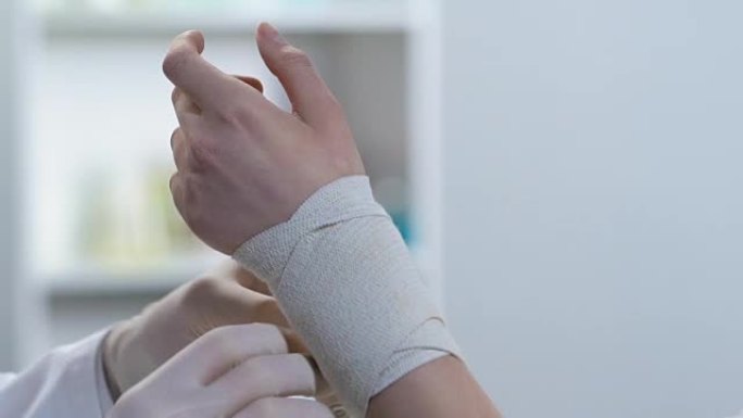 创伤专家包扎患者手腕，伸展肌肉，急救课程