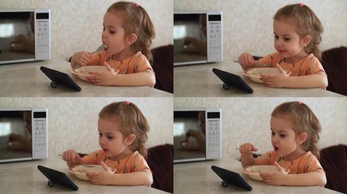 一个3岁的孩子用智能手机吃饭和看动画片。坏习惯。真实的场景。