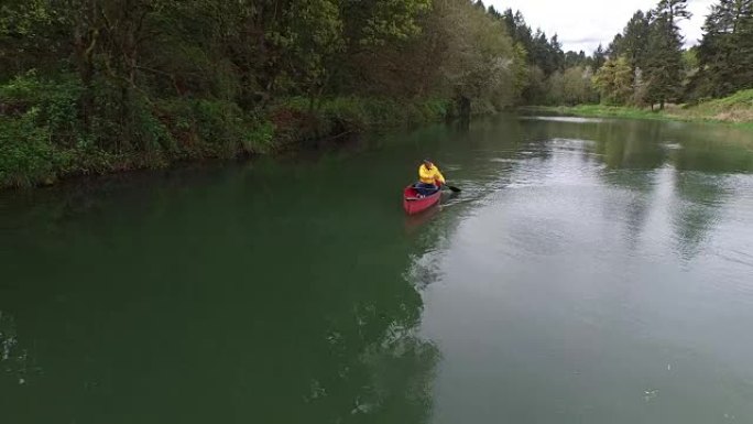 男子在湖中划桨独木舟的空中射击