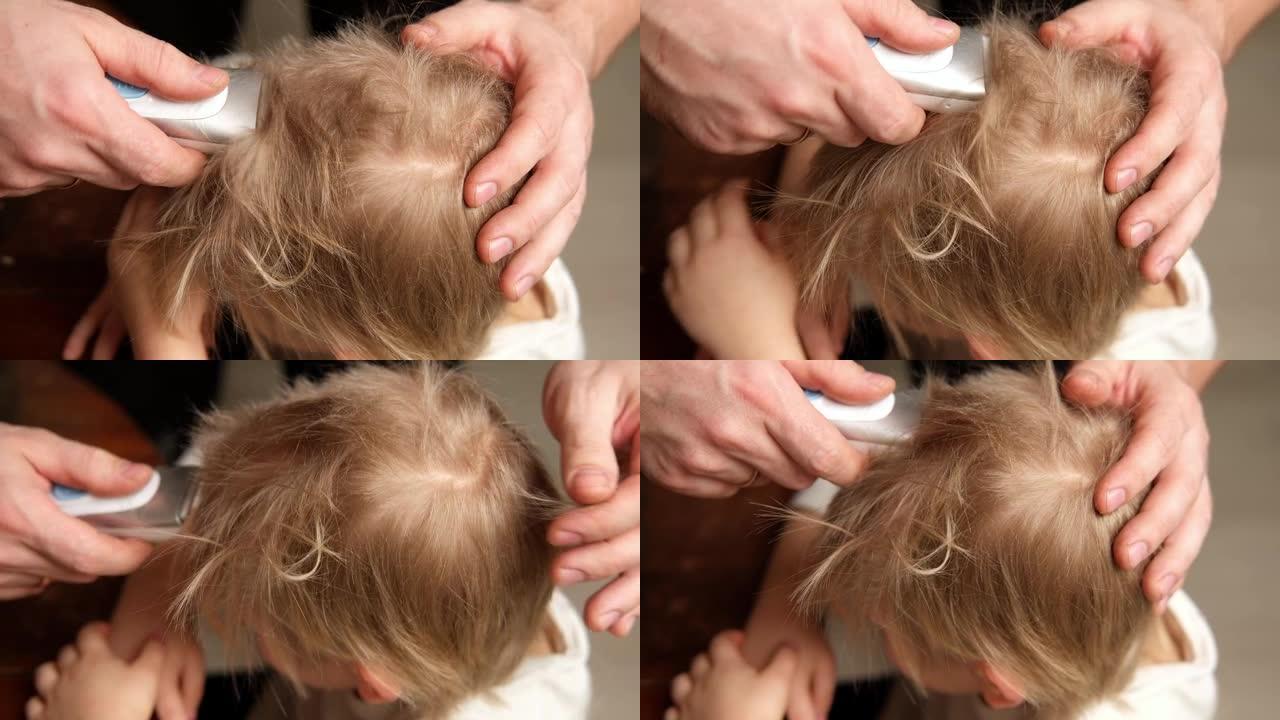 孩子的发型。理发师用理发推子剪小男孩。蹒跚学步的孩子第一次理发。父亲在家给他的小儿子剪头发。男婴在理