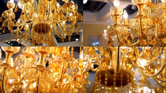 美丽的金色水晶吊灯照亮了温暖的琥珀色灯光