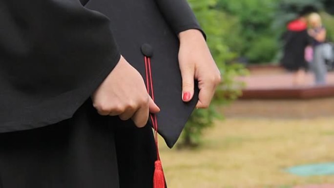 女学生手中的红色流苏毕业帽，成就，未来