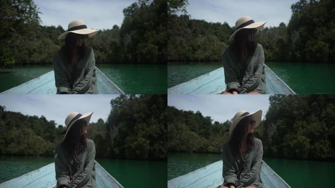 一名年轻女子在岛屿附近的一艘小船上的特写镜头